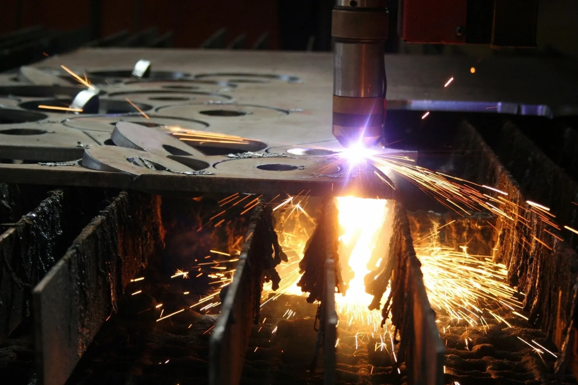 A machine cutting metal with sparks flying.