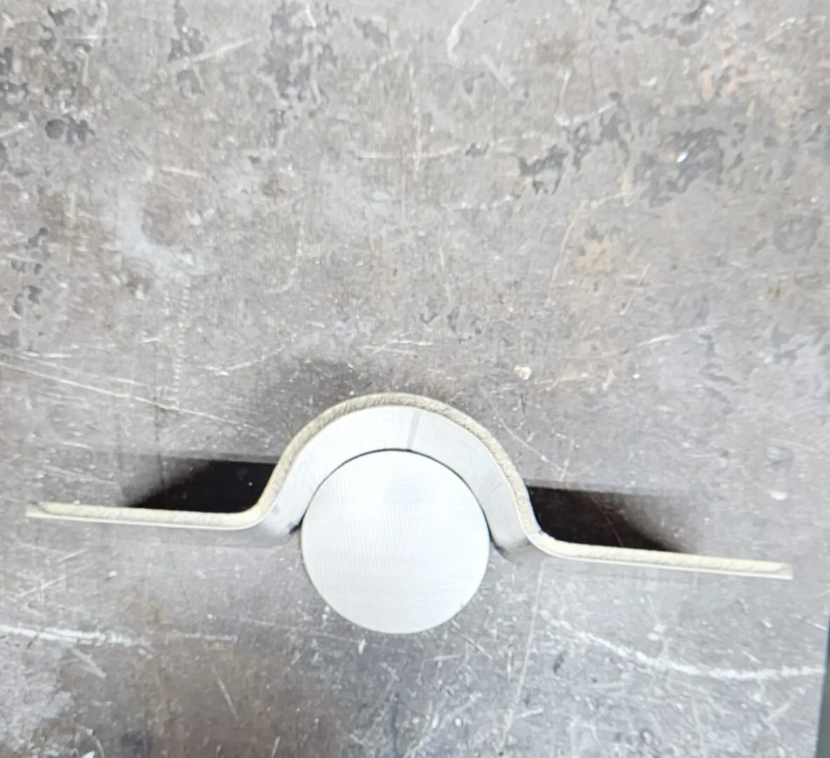 A white knob on the side of a wall.