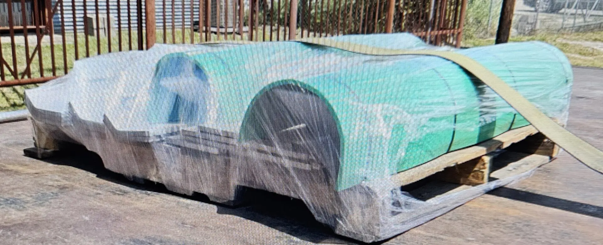 A car covered in tarp on the street.