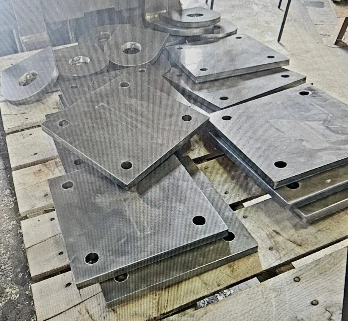 A pile of metal plates sitting on top of a wooden floor.