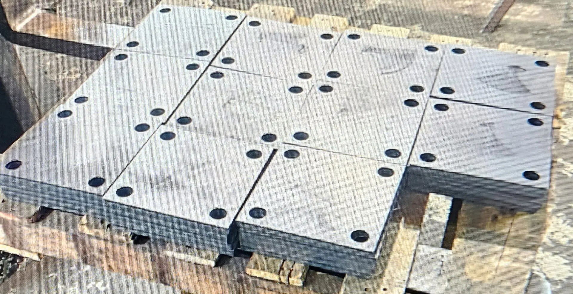 A bunch of metal plates sitting on top of pallets.