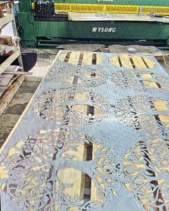 A machine cutting metal with yellow and blue designs.