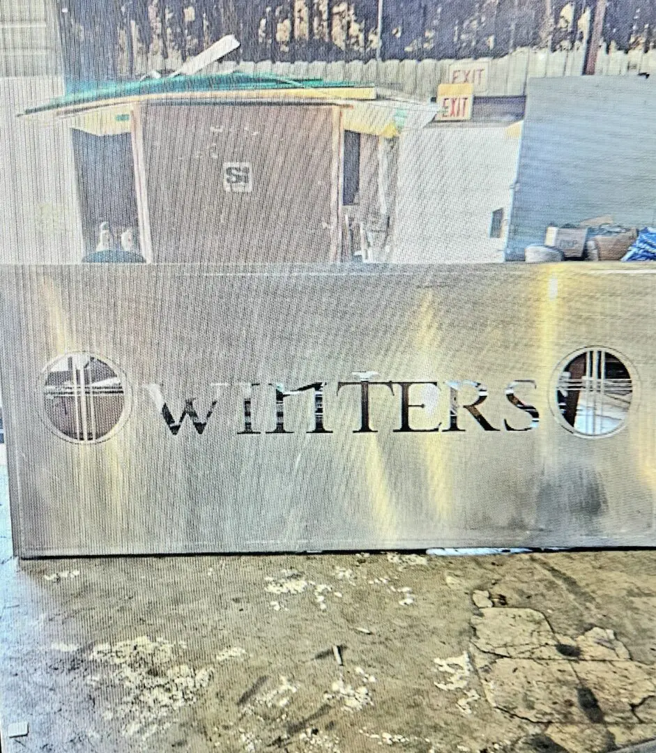 A metal sign that says whitters