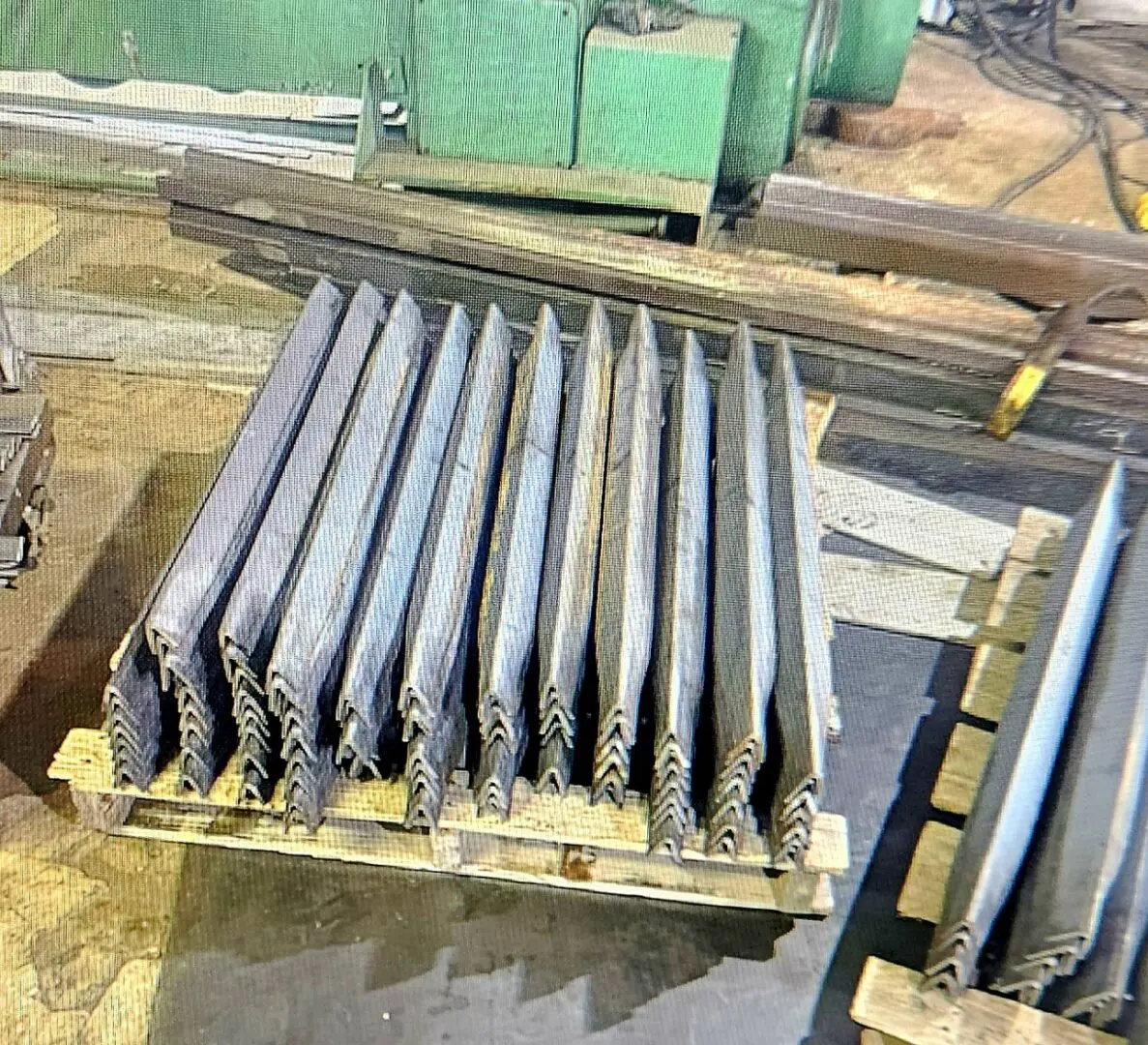 A pallet of metal bars on top of wooden pallets.