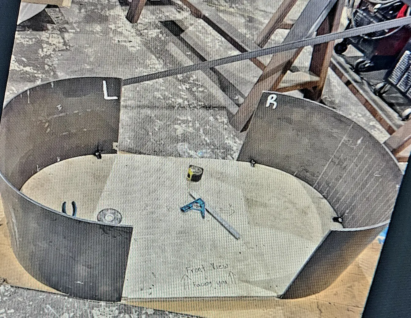 A cement pit with a wrench and nut on it.