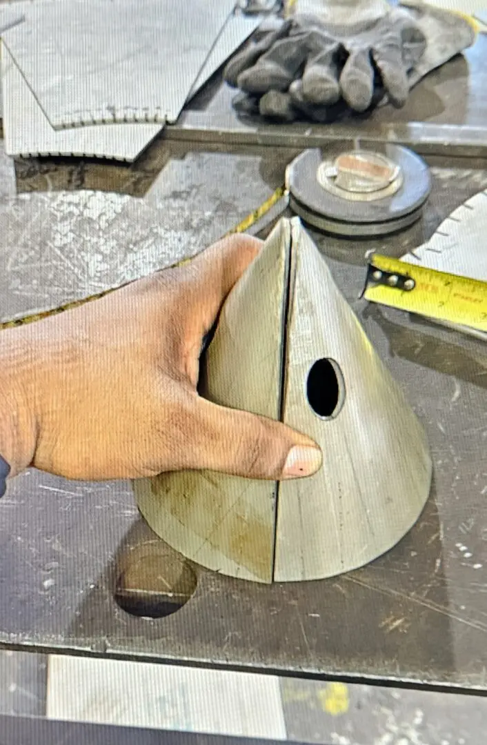 A person holding onto the top of a wooden bird house.