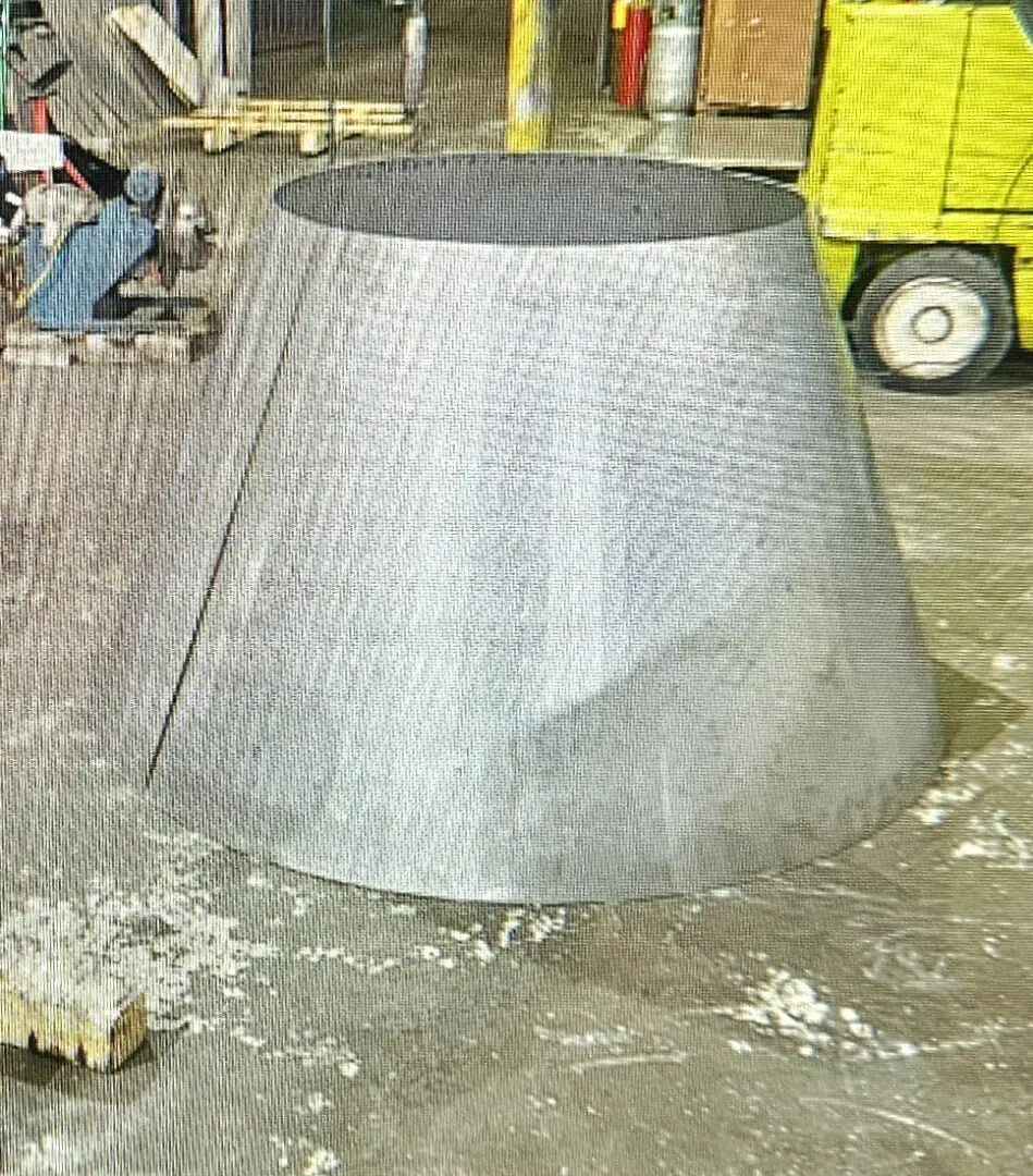 A large metal cone sitting in the middle of a concrete floor.