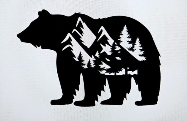 A bear with trees and mountains in the background.